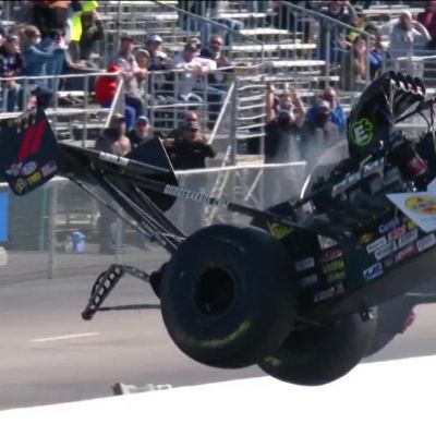 The car can be seen flying in the air while people are watching on.